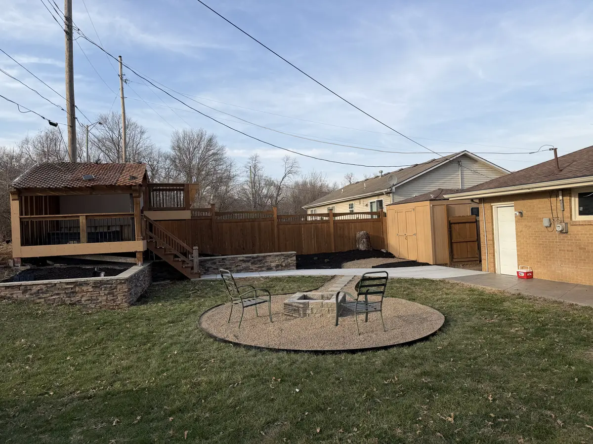 Stamped concrete patio with a fire pit at dusk in a Smithville backyard