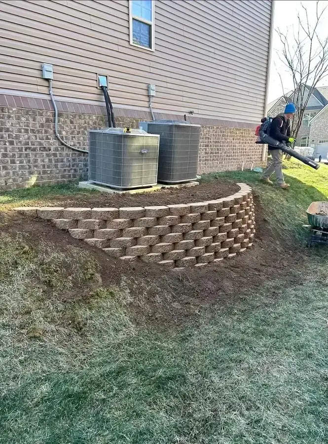 Curved segmental block retaining wall on a sloped backyard — retaining wall contractor in Smithville MO